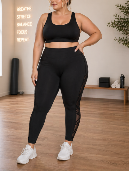 Woman in black athletic wear standing in a room with motivational text on the wall.