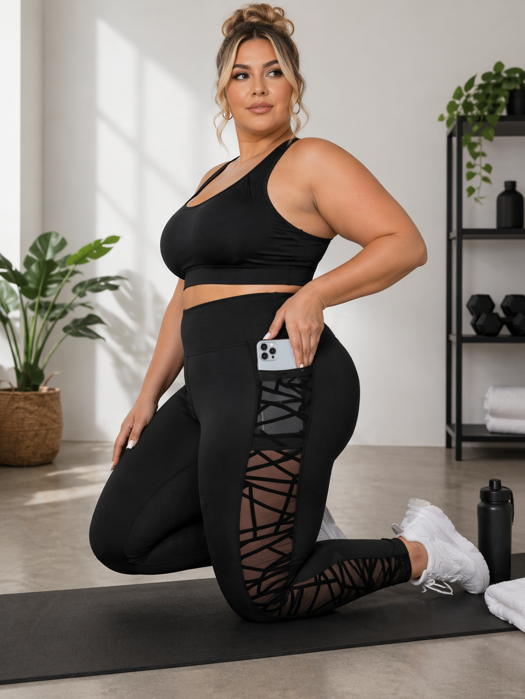 Woman in black athletic wear posing on a mat in a home setting